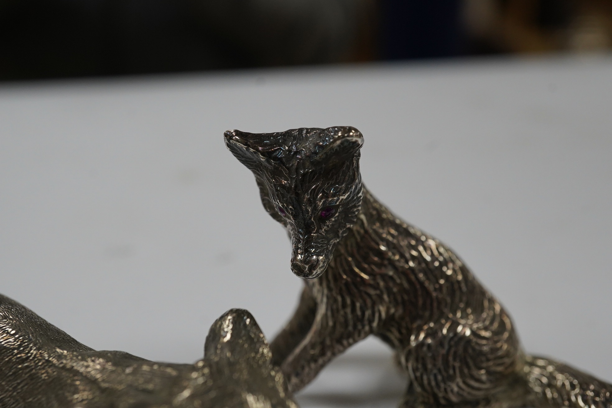 Two 1960's silver miniature models of a fox, both London, 1968, seated by Edward Barnard & Sons Ltd, height 38mm and one other smaller silver model of a running fox, 6.7oz. Condition - fair to good